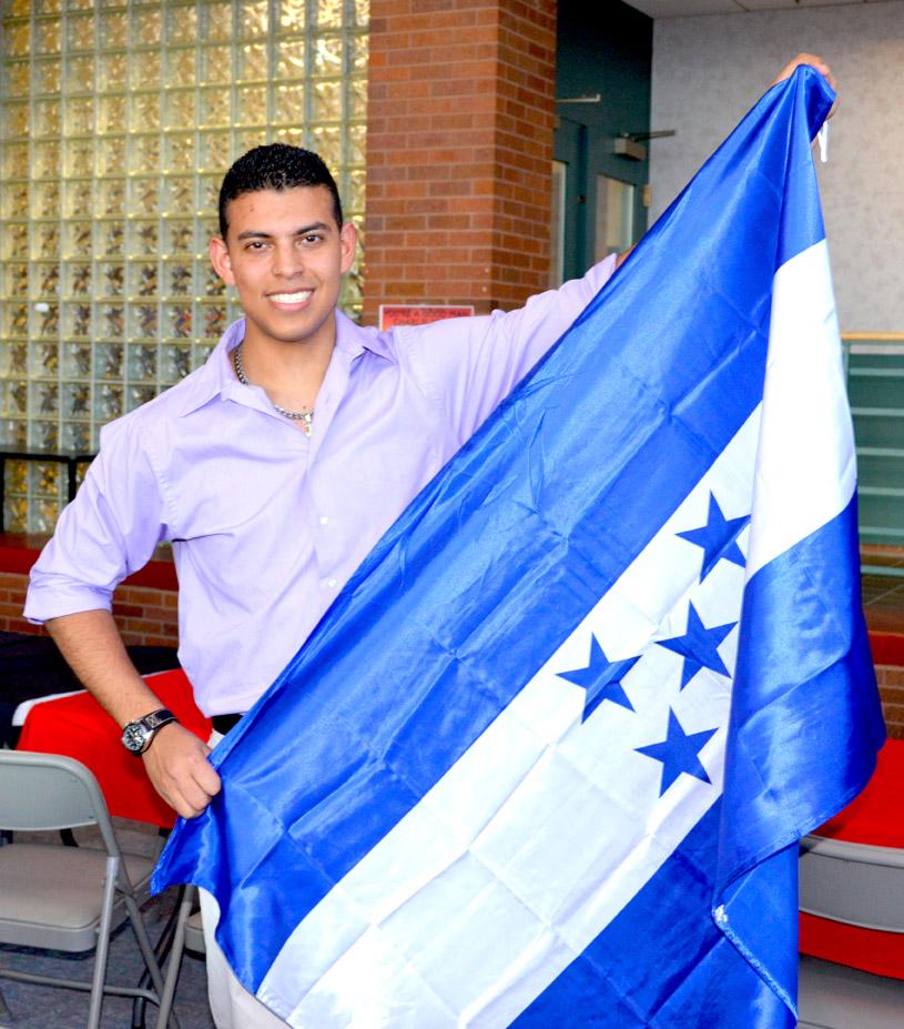 A student holding their country flag of origin. 