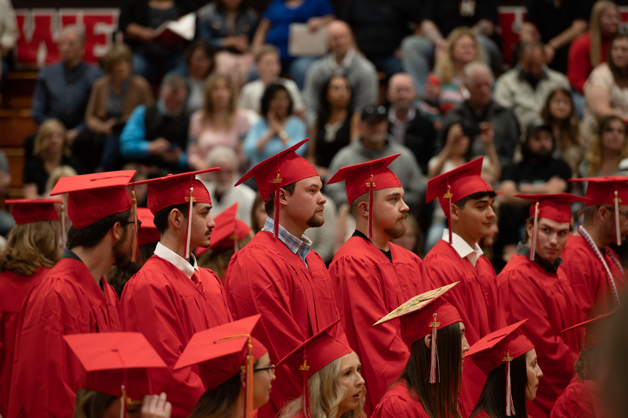 Students standing and sitting during the graduation ceremony