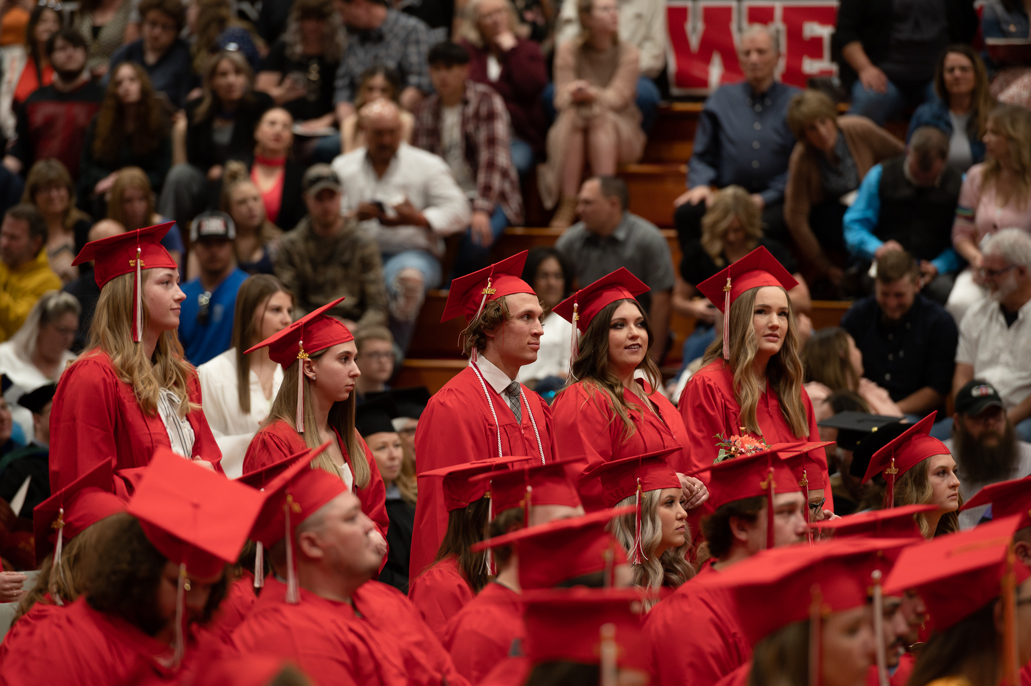 Students standing and sitting during the graduation ceremony