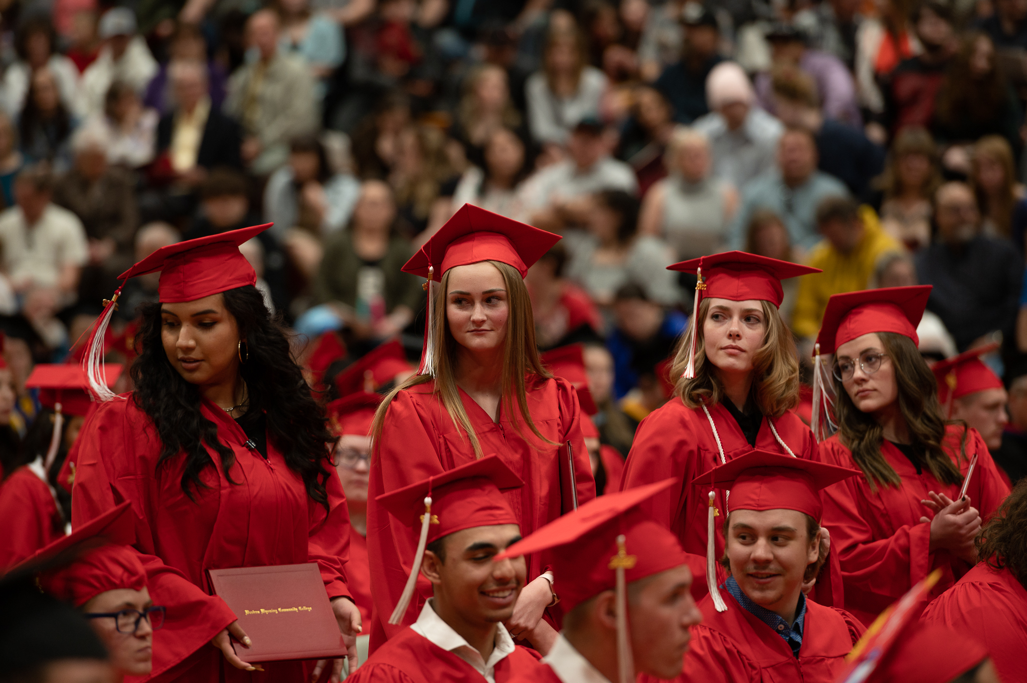 Students standing and sitting during the graduation ceremony