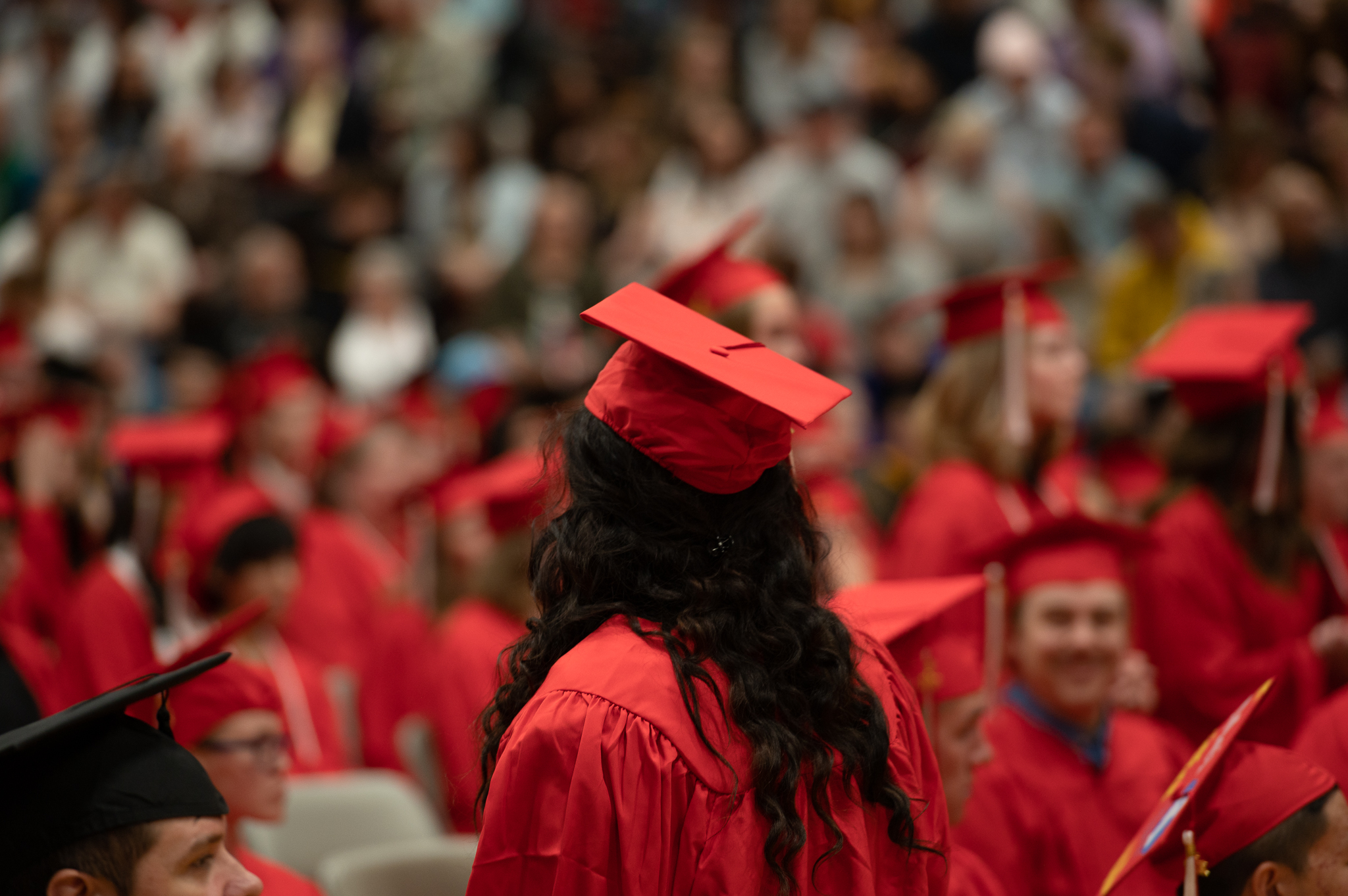 Students standing and sitting during the graduation ceremony