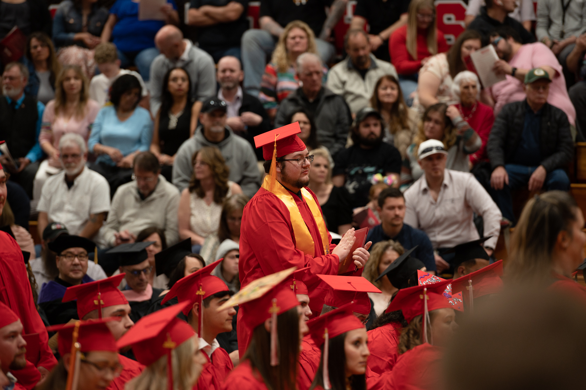 Students standing and sitting during the graduation ceremony