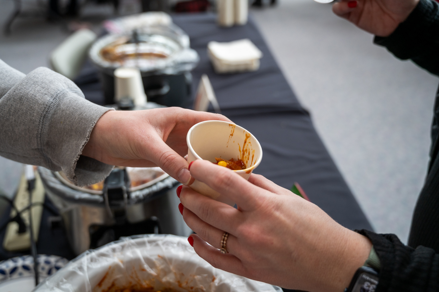 Someone Handing Over Chili Cup Sample