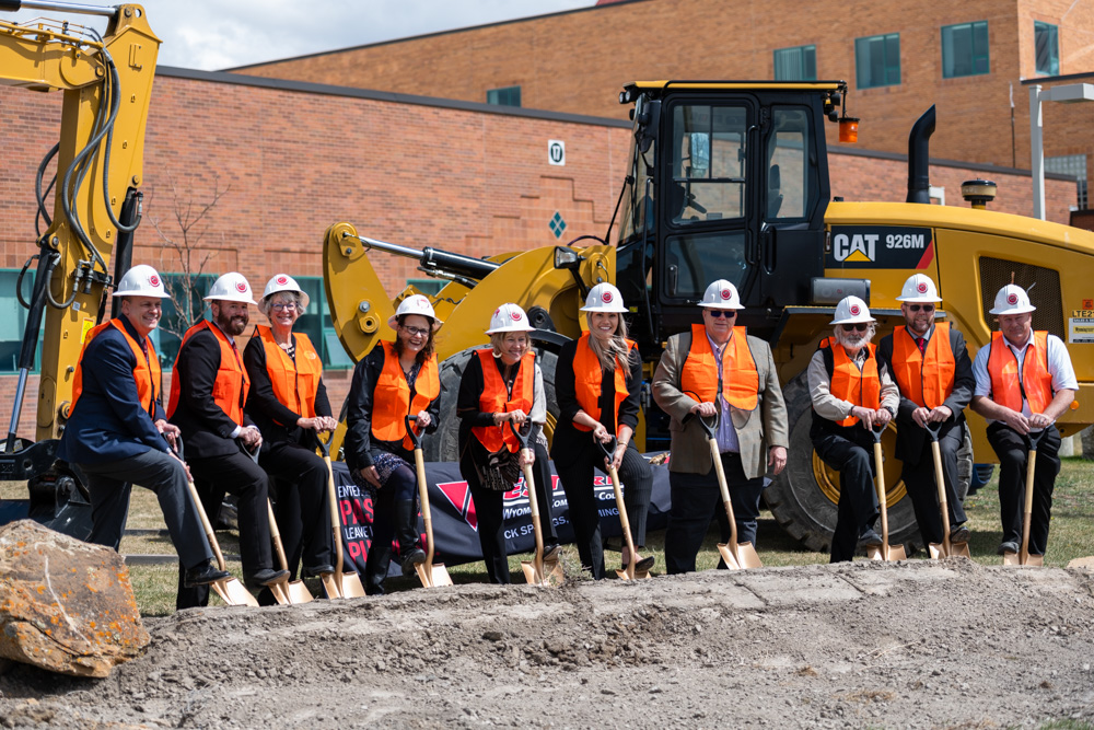 Group photo of Western Board of Trustees, Dr. Kim Dale President, VP Administrative Services Burt Reynolds, Nursing Chair Heidi Brown and Director of Facilities Chris Dever posing with golden shovels in hand ready to dig at the construction site. 