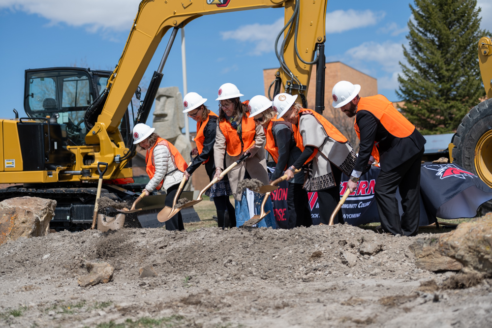 Group photo of community partners with Dr. Kim Dale President, Nursing Chair Heidi Brown and VP Administrative Services Burt Reynolds digging with golden shovels at construction site. 