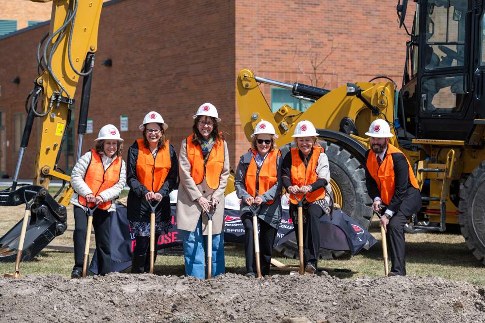 Group photo of community partners with Dr. Kim Dale President, Nursing Chair Heidi Brown and VP Administrative Services Burt Reynolds posed with golden shovels at construction site. 