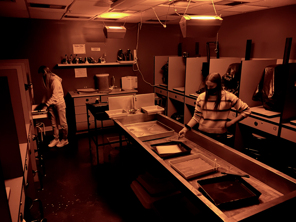 A picture of students in the darkroom processing photos. 