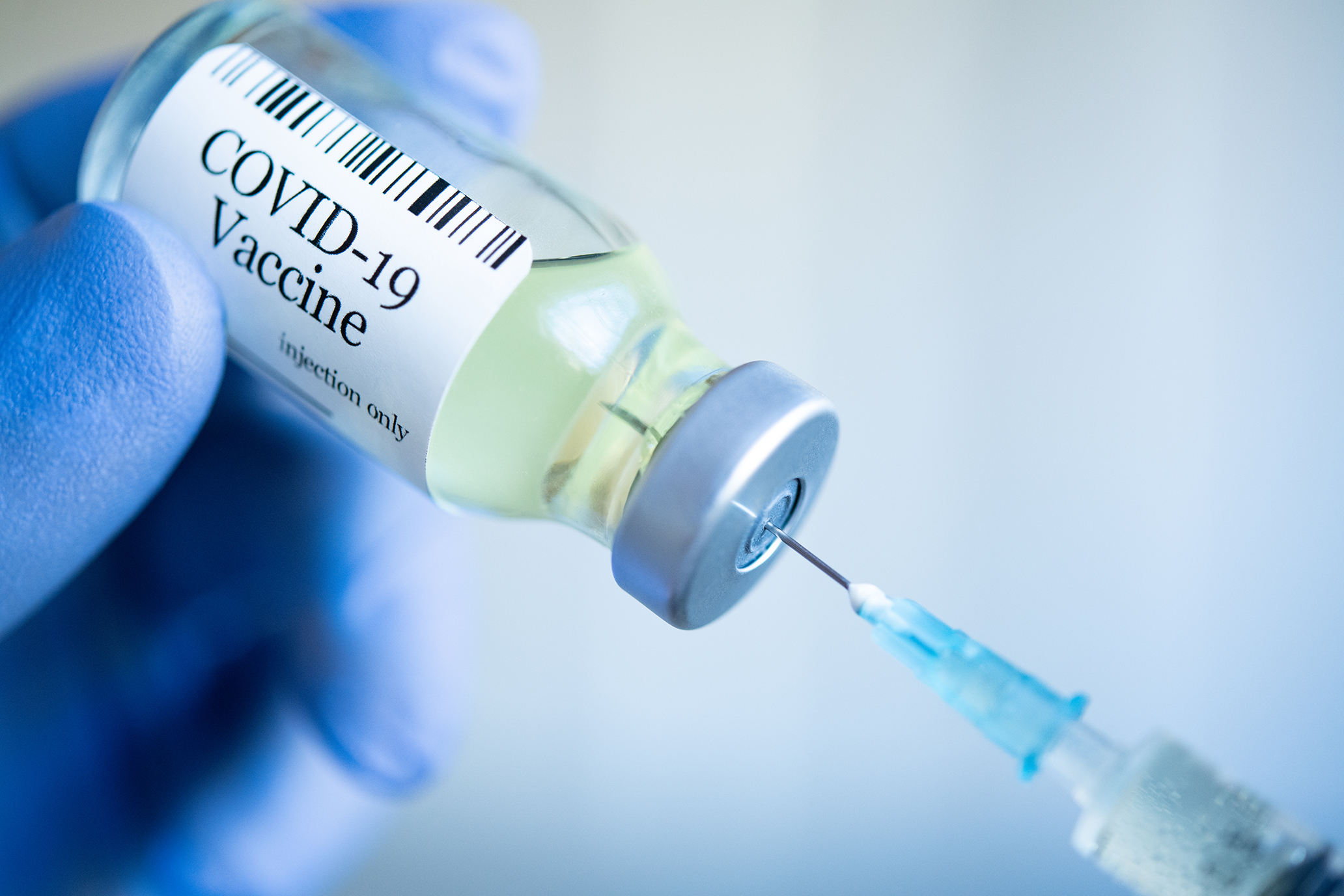 A nurse pulling a syringe of the COVID-19 vaccine. 