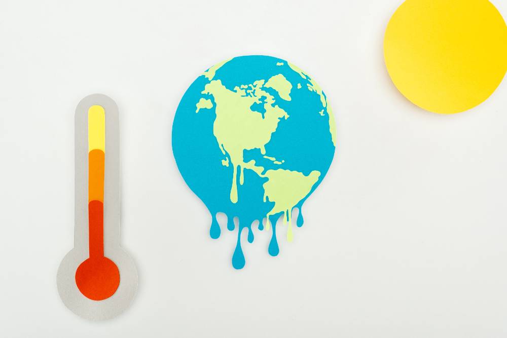 paper cut sun and melting earth, and thermometer with high temperature indication on scale on grey
