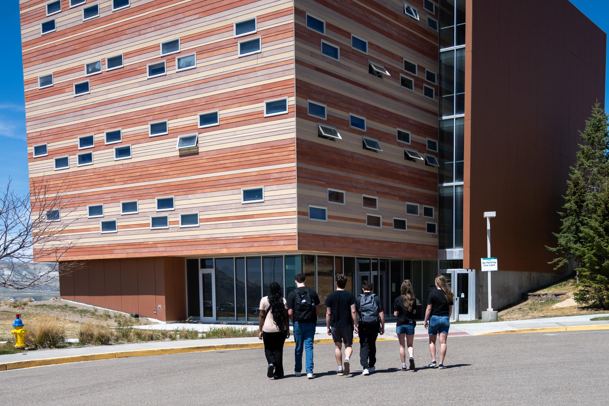 A group of six student ambassadors walk toward the Wind River dorm on Western Wyoming College's main campus